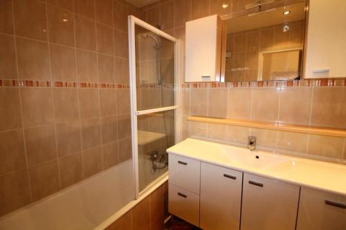 une salle de bain avec un lavabo, une douche et un miroir dans l'établissement Résidence Bec Rouge - vue lac, sur les pistes MAE-3545, à Tignes
