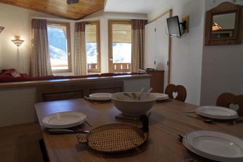 une table de salle à manger avec des assiettes et un bol dessus dans l'établissement Résidence Callisto - 3 Pièces pour 7 Personnes 70, à Mâcot La Plagne