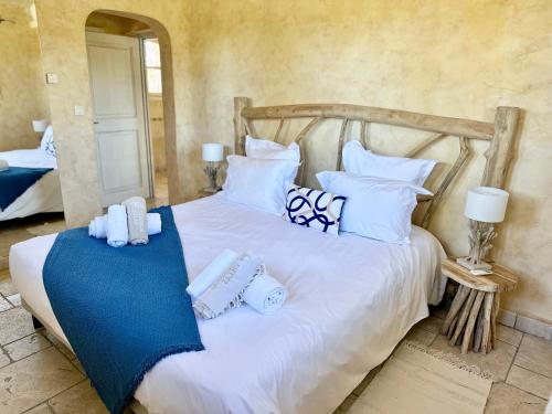 - une chambre dotée d'un lit blanc avec des oreillers bleus et blancs dans l'établissement Magnifique Villa de Luxe avec Piscine, à Porto-Vecchio