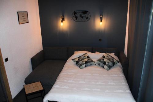 - un lit dans une petite chambre avec 2 oreillers dans l'établissement Résidence Amethyste - Studio pour 4 Personnes 47, à Mâcot La Plagne