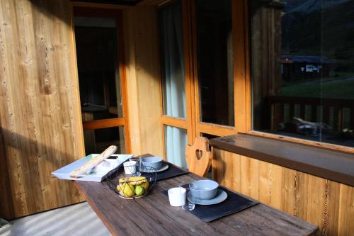 - une table avec un bol de fruits sur une terrasse couverte dans l'établissement Résidence Amethyste - Studio pour 4 Personnes 47, à Mâcot La Plagne