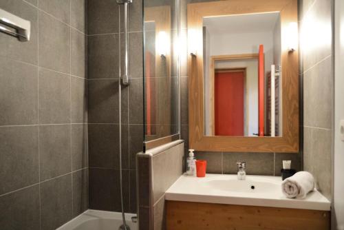 une salle de bain avec un lavabo et une douche avec un miroir dans l'établissement Résidence Nereides - 3 Pièces pour 7 Personnes 67, à Mâcot La Plagne