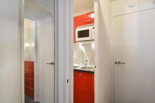 une petite cuisine avec un évier et un micro-ondes dans l'établissement Résidence Saint Jacques A - Studio pour 4 Personnes 46, à Mâcot La Plagne