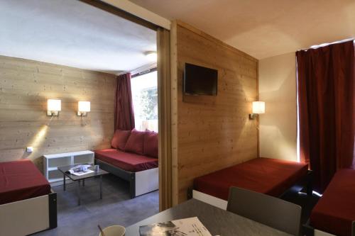 Cette petite chambre comprend un canapé et une table. dans l'établissement Résidence Saint Jacques A - Studio pour 4 Personnes 46, à Mâcot La Plagne