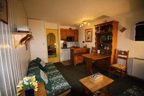 un salon avec un canapé et une cuisine dans l'établissement Résidence Home Club 2 - Studio chaleureux et confortable MAE-3576, à Tignes