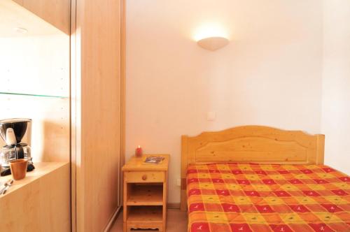 une petite chambre avec un lit et une table de chevet dans l'établissement Résidence Aigue-marine - 2 Pièces pour 5 Personnes 82, à Mâcot La Plagne