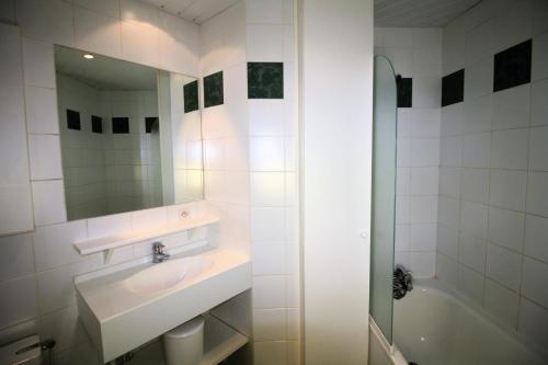 a bathroom with a sink and a mirror and a tub at Résidence Roches Rouges C - studio confortable, pied des pistes MAE-3580 in Tignes