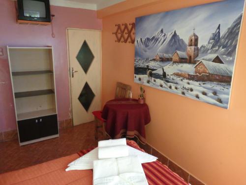 una habitación con una mesa y una pintura en la pared en Hostal "Oro Blanco", en Uyuni
