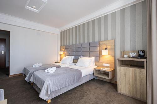 a hotel room with a bed with two towels on it at Hotel Kopczyński in Dobre Miasto