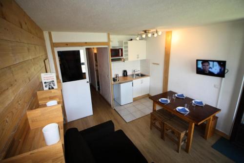 Ce petit appartement comprend une table et une cuisine. dans l'établissement Résidence Home Club 1 - studio rénové, chaleureux MAE-3601, à Tignes