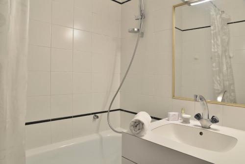 une salle de bain blanche avec un lavabo et une douche dans l'établissement Résidence Carroley A - 2 Pièces pour 5 Personnes 07, à Mâcot La Plagne