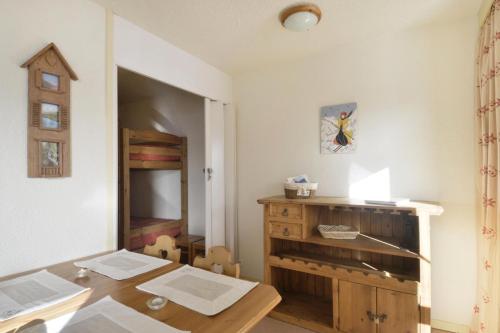 une salle à manger avec une table et une commode en bois dans l'établissement Residence 3000 - Studio pour 4 Personnes 13, à Mâcot La Plagne