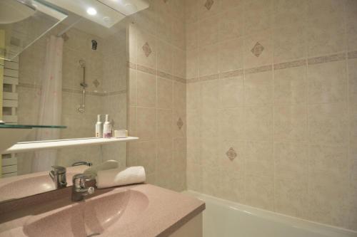 une salle de bain avec un lavabo et une baignoire dans l'établissement Residence 3000 - Studio pour 4 Personnes 13, à Mâcot La Plagne