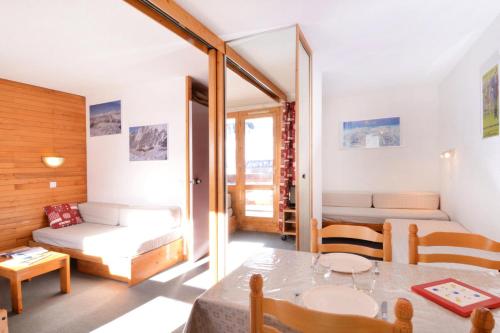 Cette petite chambre comprend une table et un canapé. dans l'établissement Résidence Les Glaciers 3 - Studio pour 4 Personnes 28, à Mâcot La Plagne