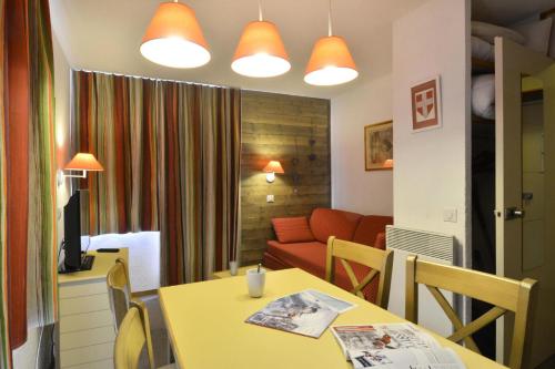 - un salon avec une table jaune et un canapé dans l'établissement Résidence Croix Du Sud - Studio pour 4 Personnes 37, à Mâcot La Plagne