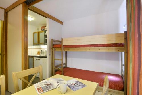 Cette petite chambre comprend une table et des lits superposés. dans l'établissement Résidence Croix Du Sud - Studio pour 4 Personnes 37, à Mâcot La Plagne