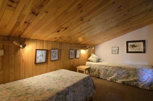 deux lits dans une chambre aux murs en bois dans l'établissement Résidence Corail - 2 Pièces pour 5 Personnes 74, à Mâcot La Plagne