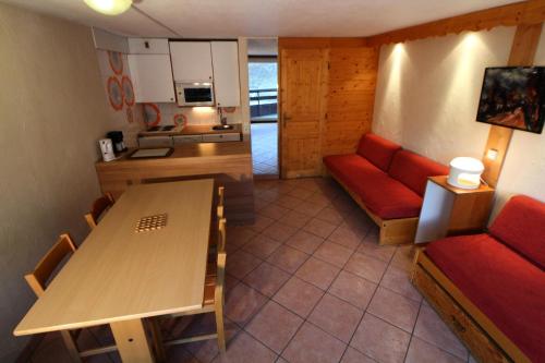 un salon avec un canapé rouge et une table dans l'établissement Résidence Palafour - grand studio 4 - vue lac MAE-3686, à Tignes