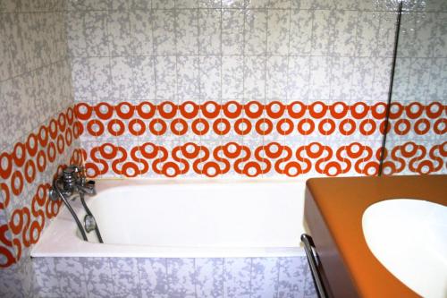 La salle de bains est pourvue d'une baignoire aux motifs rouge et blanc. dans l'établissement Résidence Palafour - grand studio 4 - vue lac MAE-3686, à Tignes
