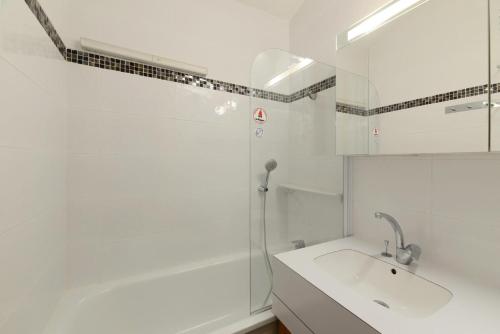 une salle de bain blanche avec un lavabo et une douche dans l'établissement Résidence Aigue-marine - 2 Pièces pour 5 Personnes 78, à Mâcot La Plagne