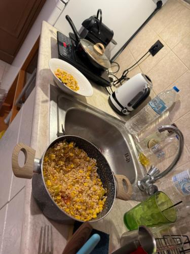 a kitchen counter with a pan of food in a sink at Breathe easy living in Tigaki