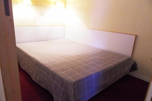 un petit lit dans une petite pièce avec un bleu dans l'établissement Résidence Themis - 2 Pièces pour 5 Personnes 94, à Mâcot La Plagne