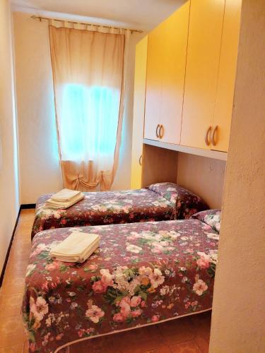 a bedroom with two beds and a window at La Casetta di Quercia in Olivola