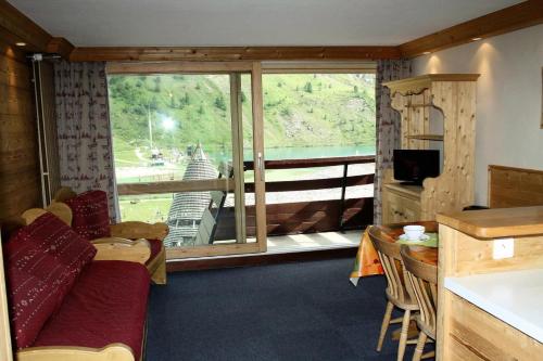 un salon avec un canapé et une grande fenêtre dans l'établissement Résidence Palafour - Grand studio 4 - confortable - balcon - vue lac MAE-3696, à Tignes