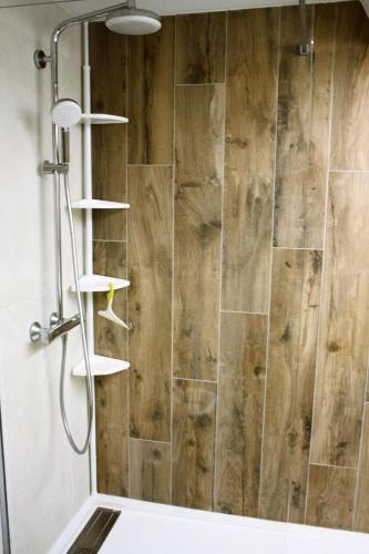 La salle de bains est pourvue d'une douche et d'un mur en bois. dans l'établissement Résidence Palafour - Grand studio 4 - confortable - balcon - vue lac MAE-3696, à Tignes