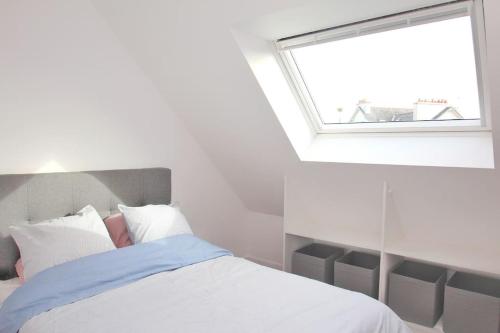 une chambre blanche avec un lit avec une fenêtre dans l'établissement Les appartements Isabelle 5 - Centre Ville, à Lorient