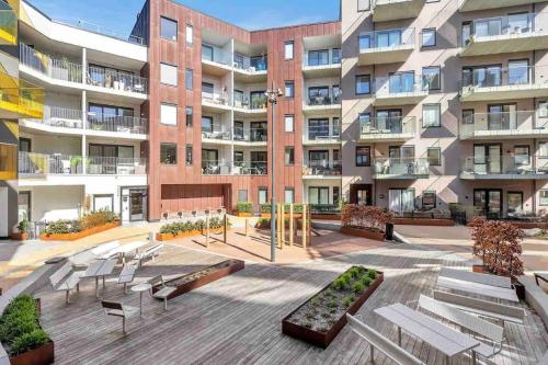 a large apartment building with benches in a courtyard at Møblert ferieleilighet i det fineste stedet i byen in Kristiansand