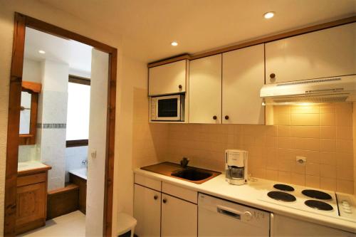 une cuisine avec un évier et un micro-ondes dans l'établissement Résidence Shamrock - charmant, rénové, confortable MAE-3718, à Tignes