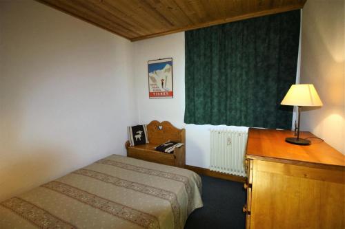 une chambre d'hôtel avec un lit et un bureau avec une lampe dans l'établissement Résidence Shamrock - charmant, rénové, confortable MAE-3718, à Tignes