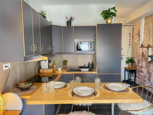 une cuisine avec une table en bois et des plaques de cuisson. dans l'établissement Coeur de Juan, Calme, 300m plages - EASY CHECK-IN, à Antibes