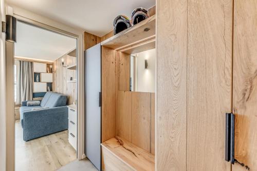 une chambre avec une porte coulissante et un canapé bleu dans l'établissement Résidence Palafour - Rénovation et confort moderne pour ce studio avec terrasse vue lac MAE-3731, à Tignes