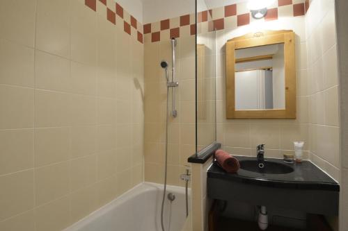une salle de bain avec un lavabo et une douche avec un miroir dans l'établissement Résidence Themis - Studio pour 4 Personnes 34, à Mâcot La Plagne