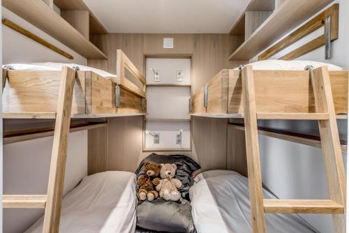 2 lits superposés avec un ours en peluche au milieu dans l'établissement Résidence Armaillis - Appartement rénové, vue lac MAE-3743, à Tignes