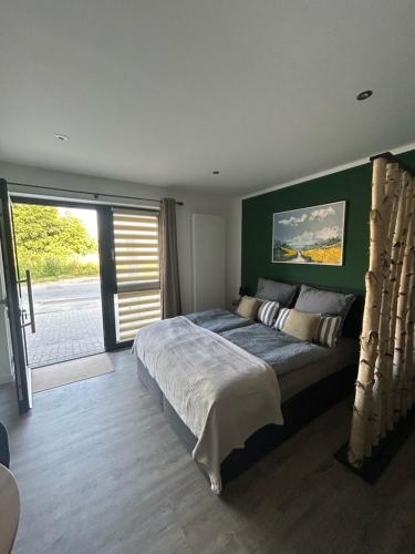 a bedroom with a large bed with a green wall at Ferienwohnungen mit Feldblick in Schwerin