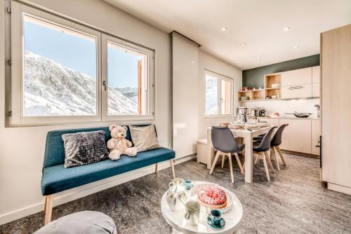 - un salon avec un ours en peluche assis sur un canapé dans l'établissement Résidence Armaillis - Appartement rénové, vue lac MAE-3743, à Tignes