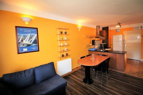 un salon avec un canapé et une table et une cuisine dans l'établissement Résidence Bec Rouge - Sur les pistes MAE-3752, à Tignes