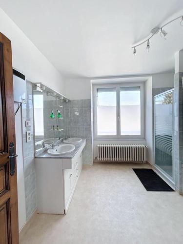La grande salle de bains est pourvue d'un lavabo et d'une fenêtre. dans l'établissement BRP Aveyron, Castan House, 5 beds, à Druelle