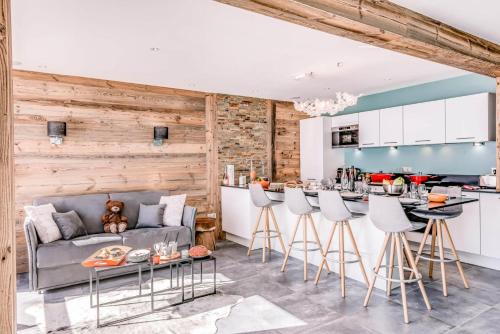 - une cuisine et un salon avec un canapé et un bar dans l'établissement Résidence Shamrock - Appartement 3 magnifiquement rénové - belle vue lac MAE-3758, à Tignes