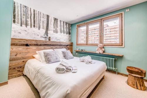 une chambre avec un lit avec un ours en peluche dessus dans l'établissement Résidence Shamrock - Appartement 3 magnifiquement rénové - belle vue lac MAE-3758, à Tignes
