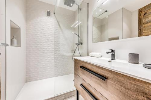 une salle de bain blanche avec un lavabo et une douche dans l'établissement Résidence Shamrock - Appartement 3 magnifiquement rénové - belle vue lac MAE-3758, à Tignes