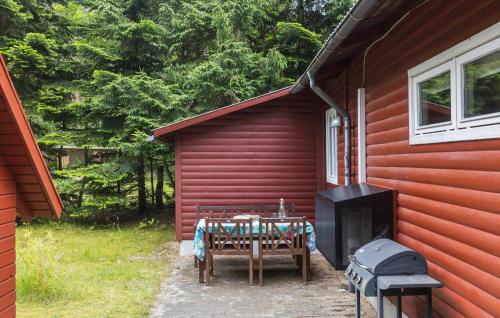 a patio with a table and a grill with a table and chairs at 2 Bedroom Amazing Home In Kolind in Kolind