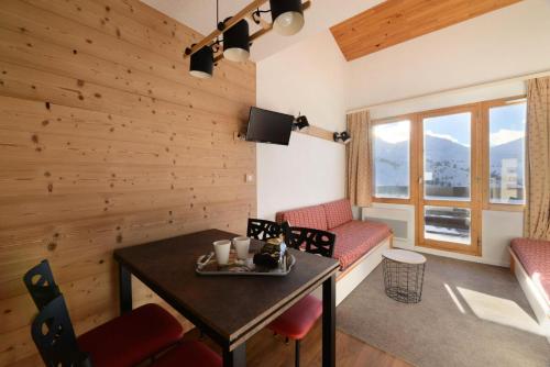 - un salon avec des murs en bois, une table et des chaises dans l'établissement Résidence Callisto - 2 Pièces pour 5 Personnes 68, à Mâcot La Plagne