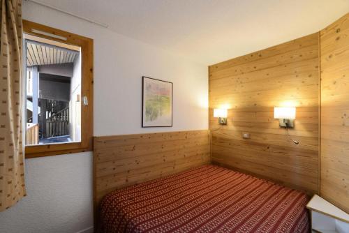 une chambre avec un lit dans une pièce avec une fenêtre dans l'établissement Résidence Callisto - 2 Pièces pour 5 Personnes 68, à Mâcot La Plagne