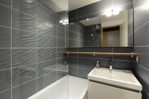 une salle de bain avec un lavabo et un miroir dans l'établissement Résidence Callisto - 2 Pièces pour 5 Personnes 68, à Mâcot La Plagne
