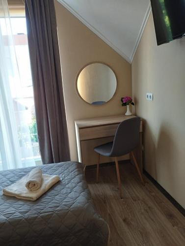 a bedroom with a bed and a desk and a mirror at садиба Лоньяї 22 in Berehove