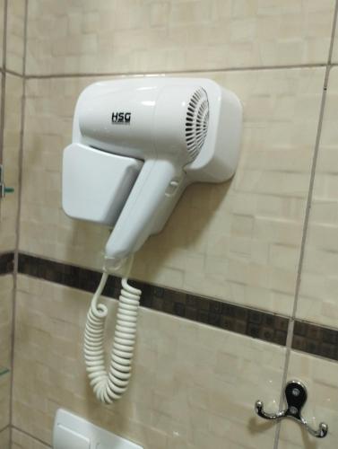 a white hair dryer on a wall in a bathroom at садиба Лоньяї 22 in Berehove